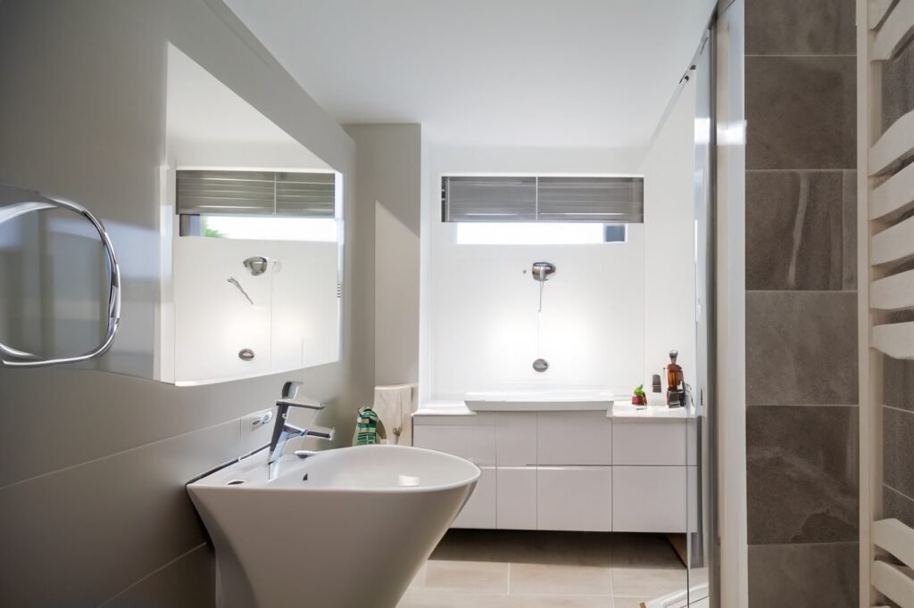 Modern bathroom showcasing elegant marble tiles, chrome fixtures, and a spacious bathtub after a complete renovation